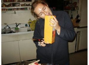 woman biting giant block of cheese