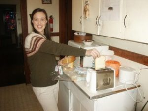 woman smiling putting bread into a toaster