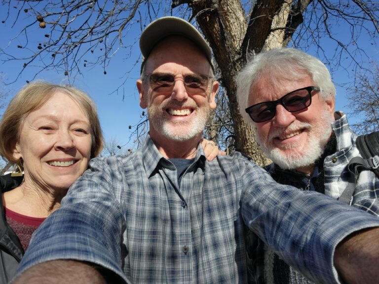 Selfie of Jay, Colleen, and Fr. Jarek under a blue sky